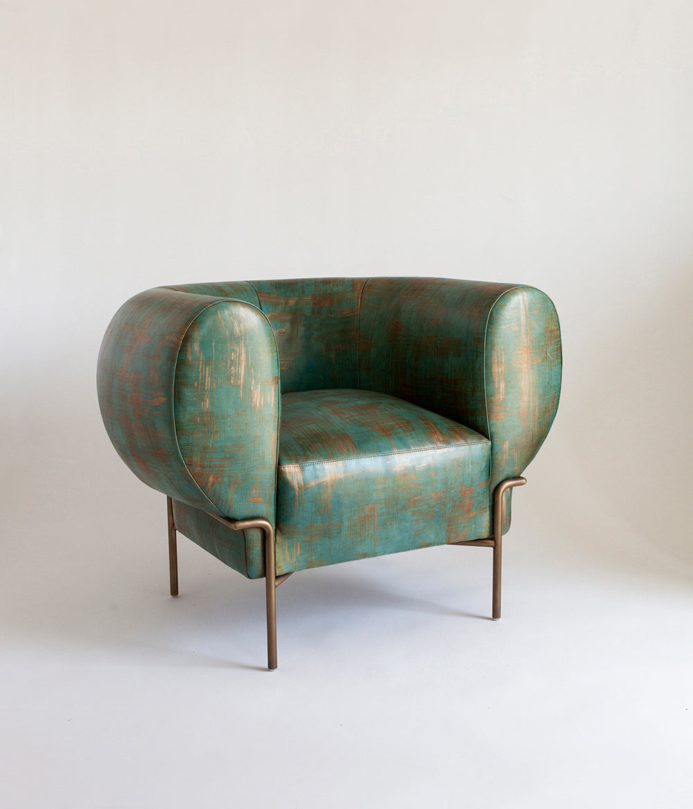 A curvilinear modernist armchair upholstered in leather in a textural brushstroke pattern in turquoise and gold.