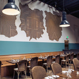 A restaurant space with cowhide wall hangings in white with geometric stripe overlays in black.