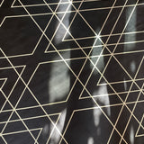 Close-up of a cowhide rug in black with a tan geometric overlay.