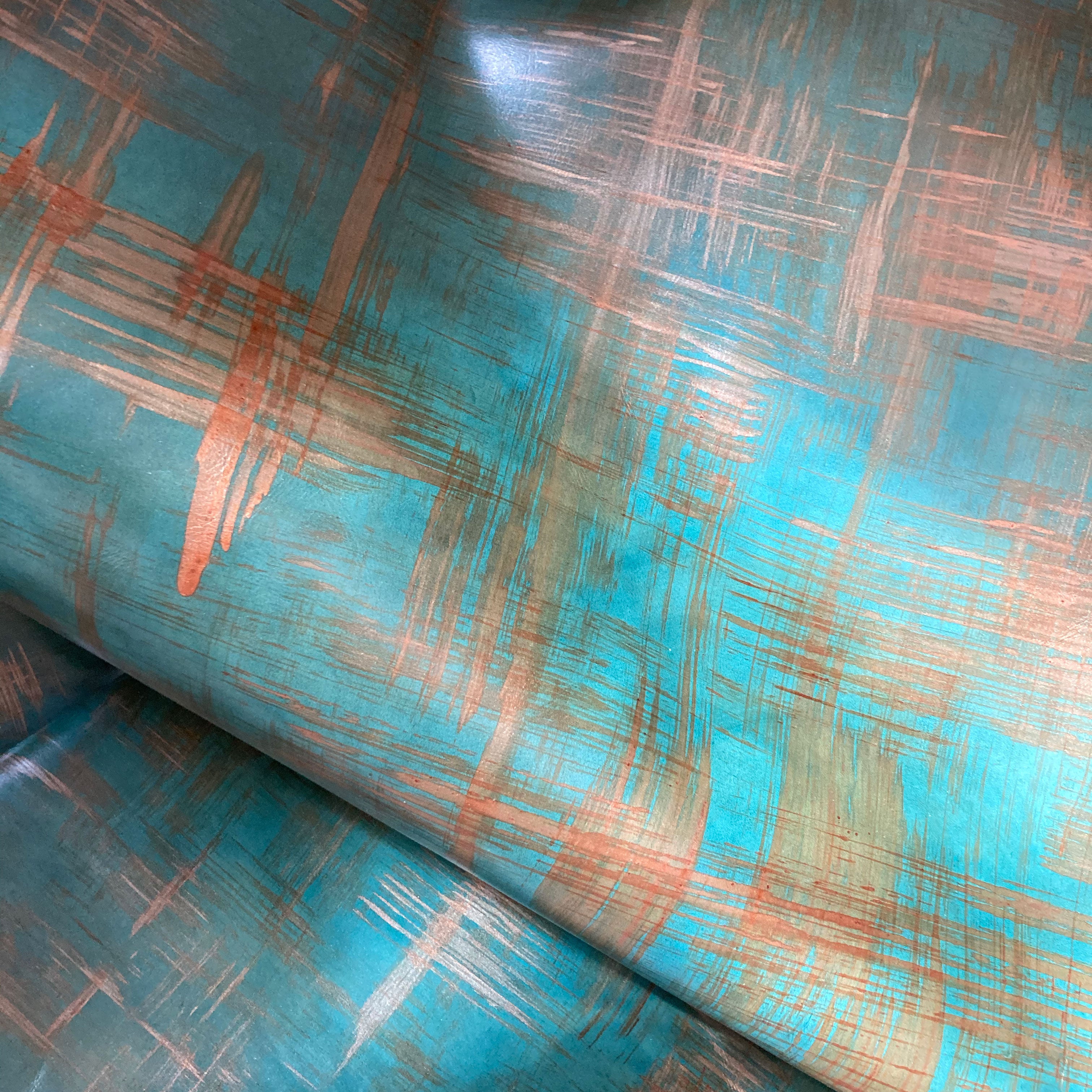 Draped upholstery leather in a textural brushstroke pattern in turquoise and gold.