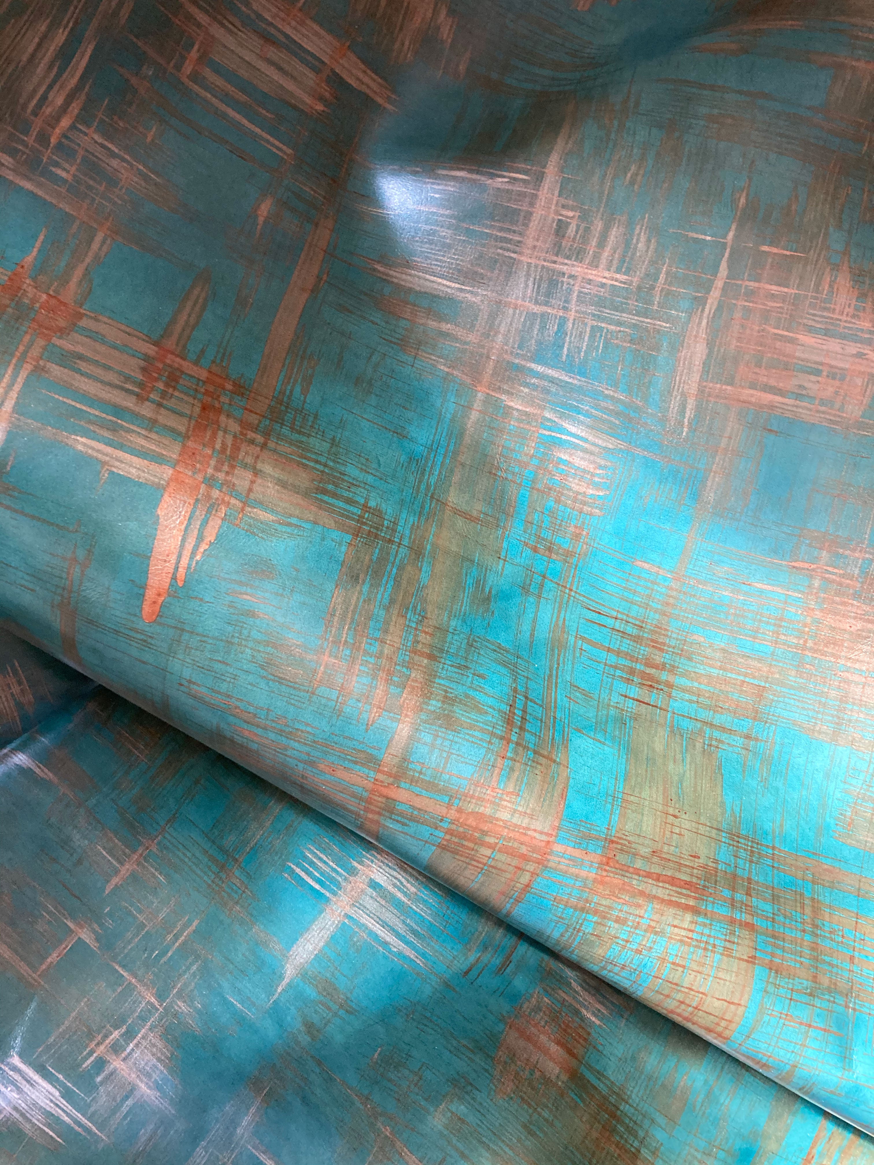 Draped upholstery leather in a textural brushstroke pattern in turquoise and gold.