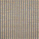 Detail of a woven leather rug in a gridded texture in gray with yellow accents.