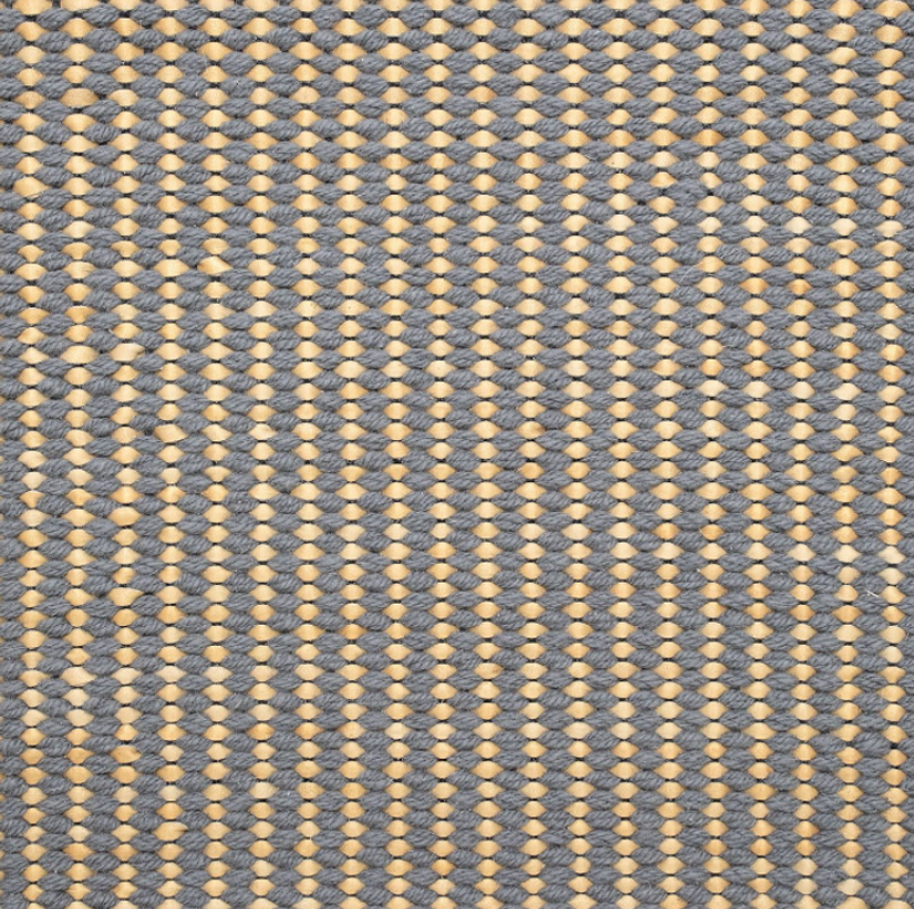 Detail of a woven leather rug in a gridded texture in gray with yellow accents.