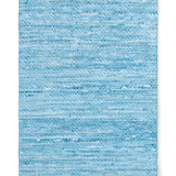 Overhead shot of a woven leather rug in a striped wave texture in shades of turquoise with cream accents.