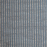 Detail of a woven leather rug in a gridded texture in blue with gray accents.