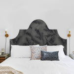 Detail of a bedroom space with a headboard upholstered in cowhide leather in gray with a black botanical overlay.