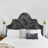 Detail of a bedroom space with a headboard upholstered in cowhide leather in gray with a black botanical overlay.