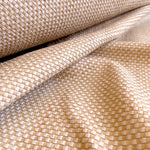 Draoed upholstery leather yardage in a woven grid in tan and white.