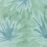 Close-up of a cowhide rug in green with a painterly flower print in shades of blue.