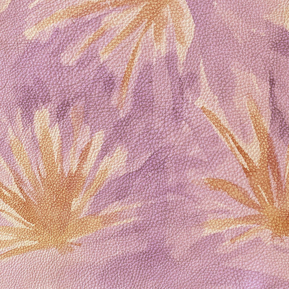 Close-up of a cowhide rug in purple with a painterly flower print in yellow and orange.