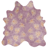 Detail of a cowhide rug in purple with a painterly flower print in yellow and orange.