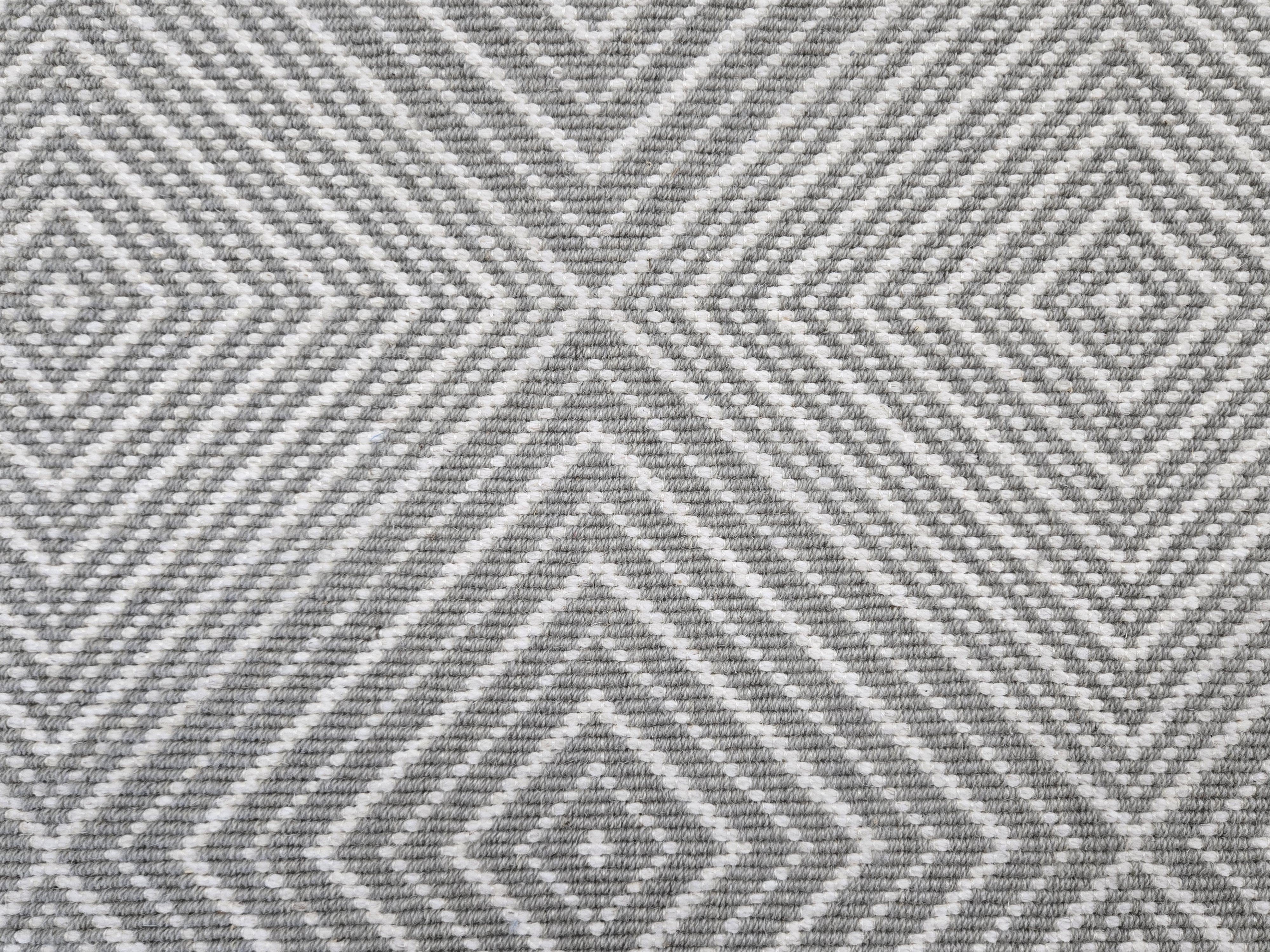 Broadloom carpet sample in a linear diamond design in white and pewter grey.