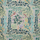 Detail of fabric in a dense floral print in shades of pink, yellow, green and black on a tan field.