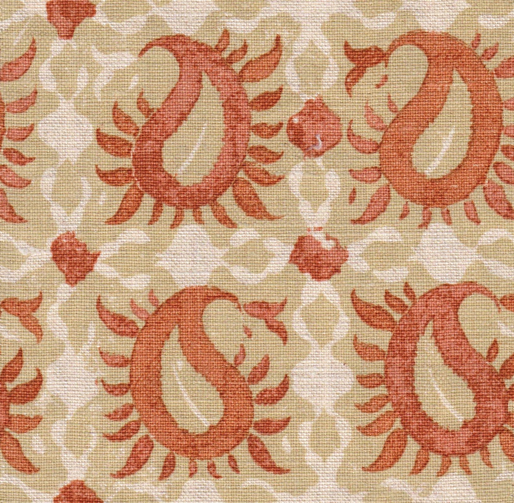 Detail of fabric in a paisley print in shades of tan and red on a white field.