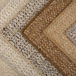 Stack of broadloom carpets in a textural weave in shades of taupe, cream, brown , blue and grey.