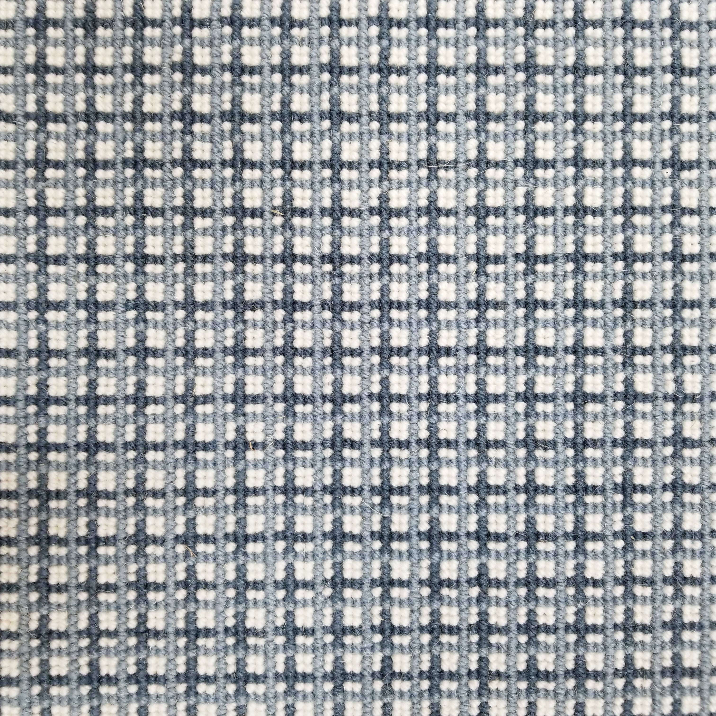 Broadloom carpet with plaid design in blue and ivory.