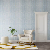 Styled living room tableau with a wall papered in a geometric stripe print in shades of blue and gray.
