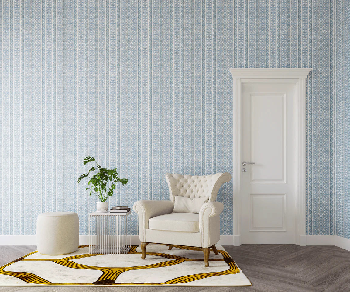 Styled living room tableau with a wall papered in a geometric stripe print in shades of blue and gray.