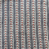 Block printed fabric in a dotted stripe in red and indigo on natural linen.