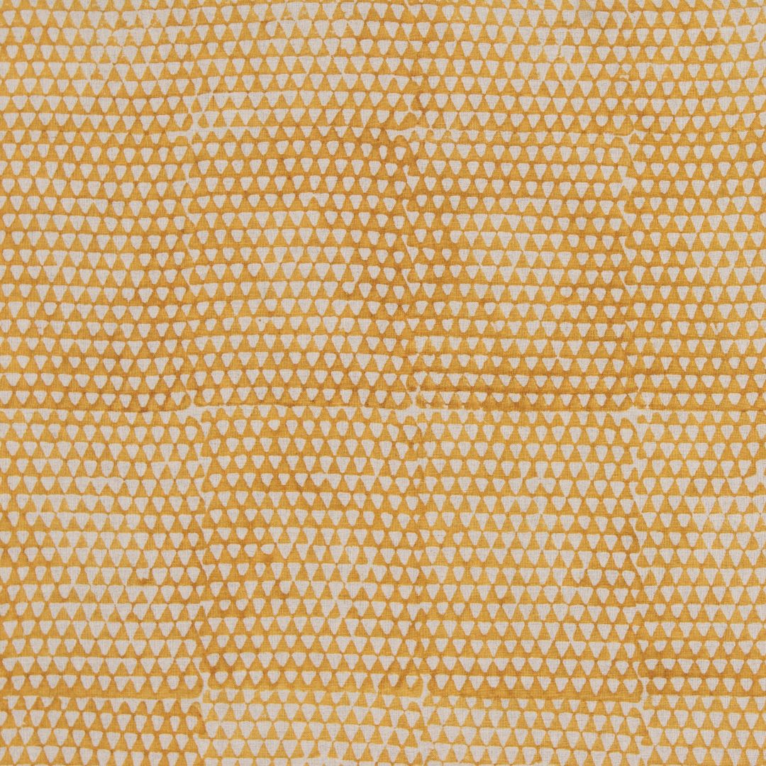 Detail of fabric in a small-scale triangle print in orange on a tan field.