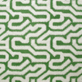 Detail of fabric in a playful meandering print in cream on a green field.