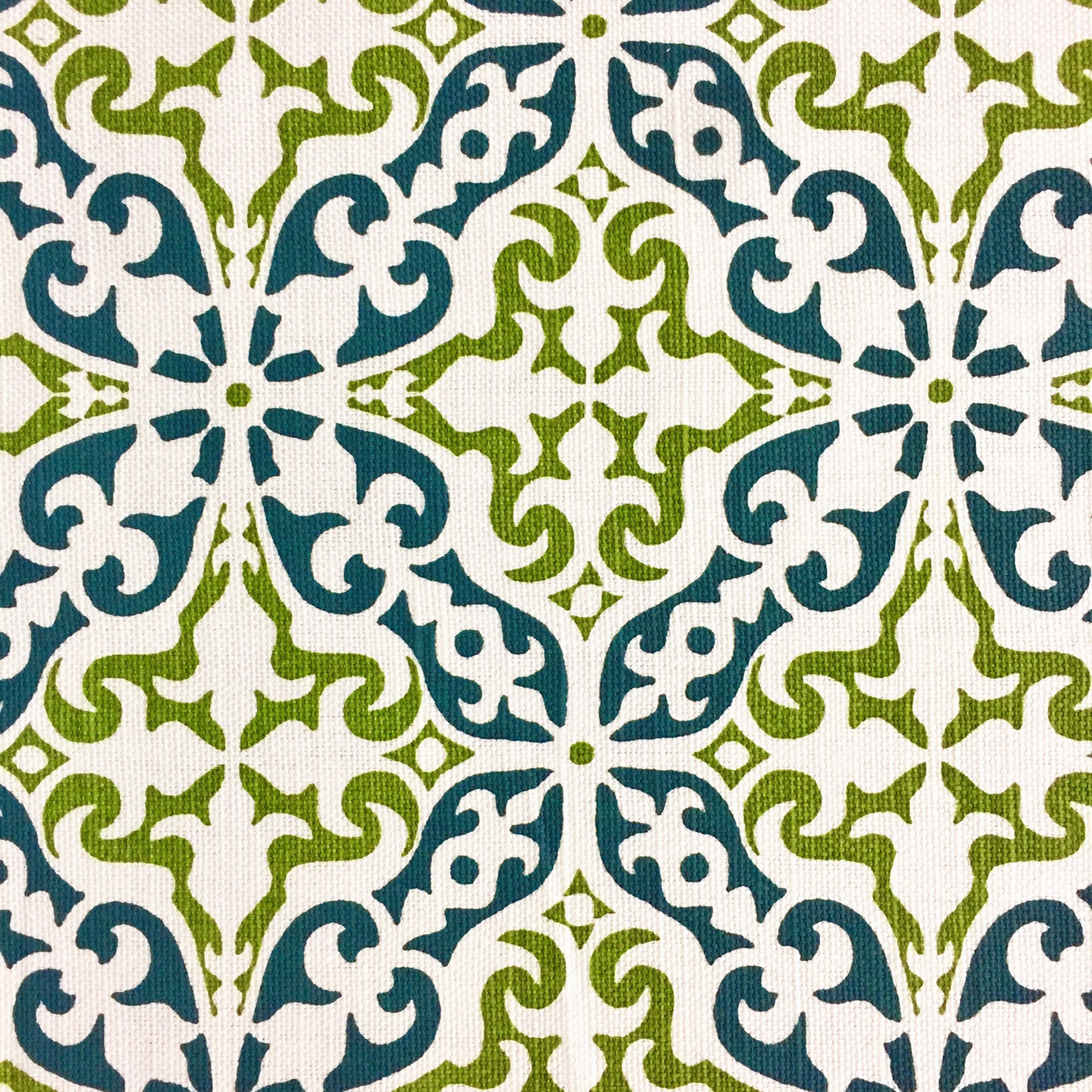 Detail of fabric in a damask print in green and navy on a cream field.