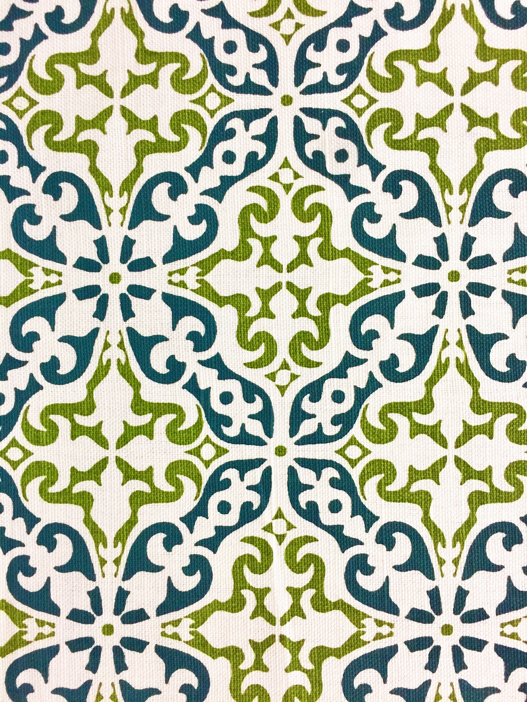 Detail of fabric in a damask print in green and navy on a cream field.