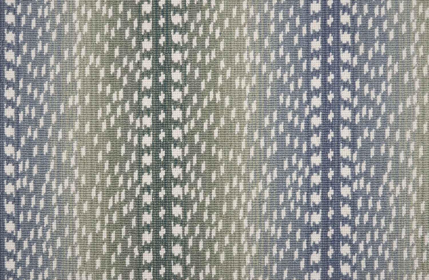 Broadloom carpet with a cream dashed stripe on an ombré field in blue and green. 