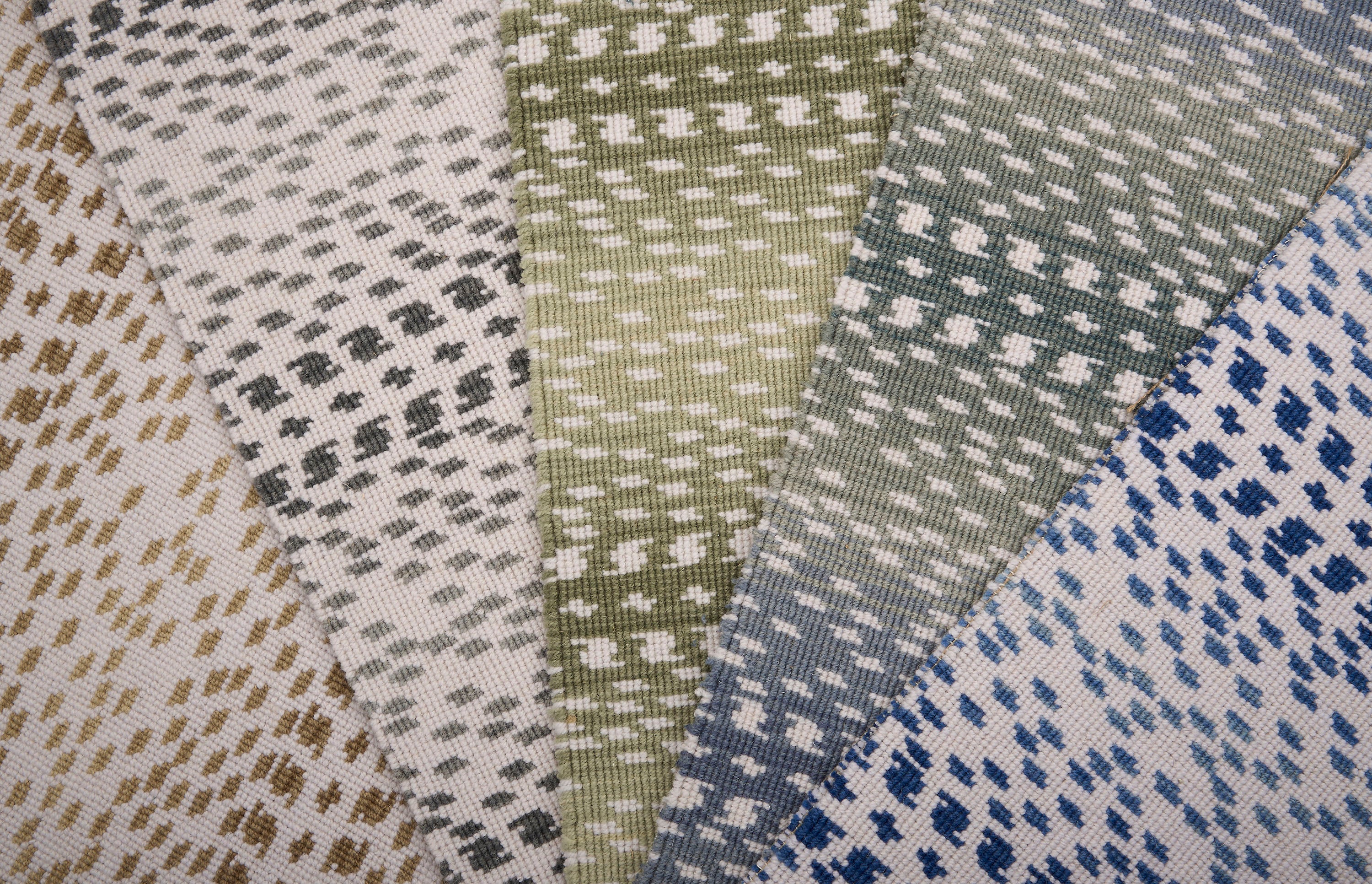 Collection of broadloom carpet swatches in ombré stripe patterns in a range of colors. 