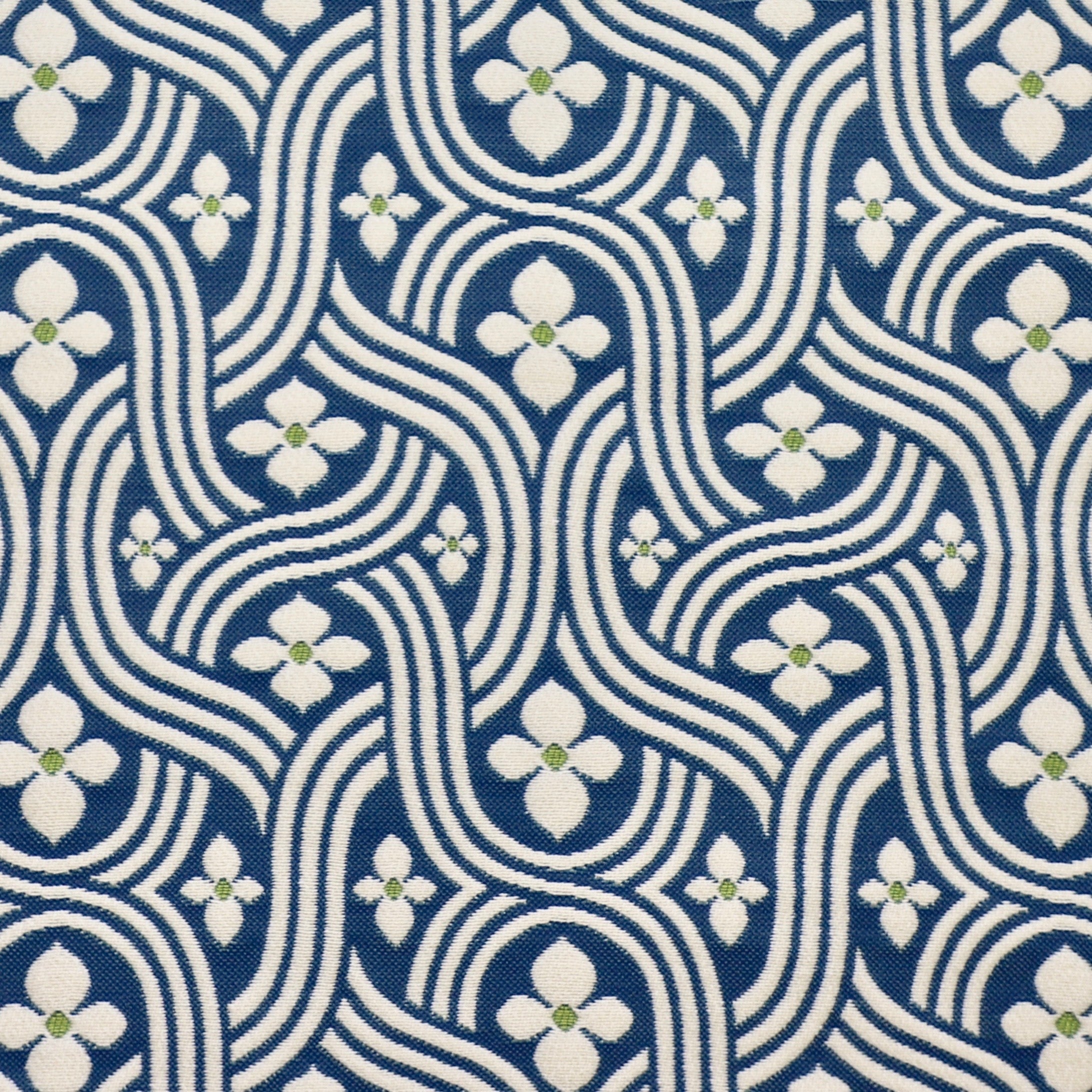 Detail of fabric in a floral damask print in white and green on a navy field.