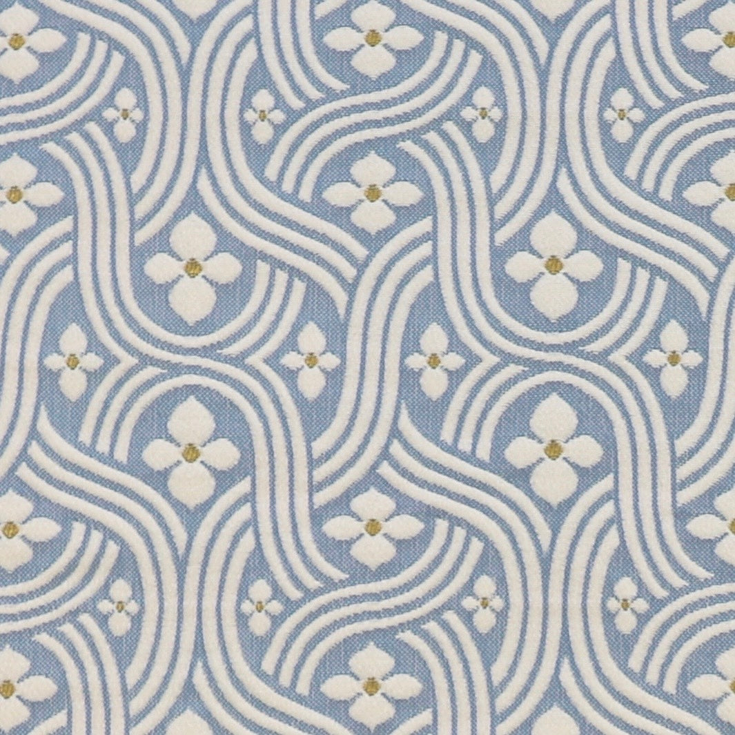 Detail of fabric in a floral damask print in white and gold on a light blue field.