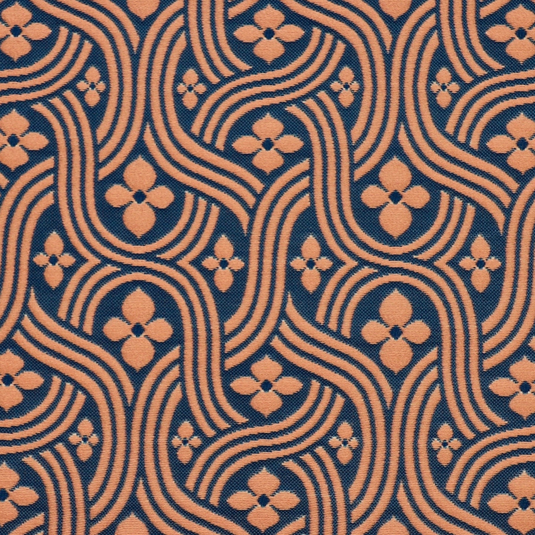 Detail of fabric in a floral damask print in orange on a dark blue field.