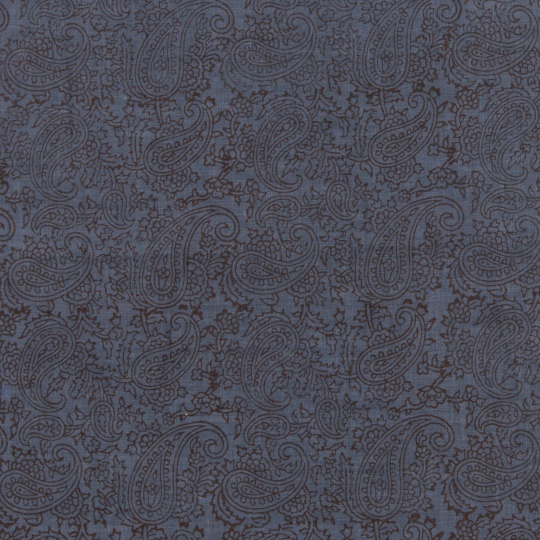 Detail of fabric in a dense paisley print in brown on a navy field.
