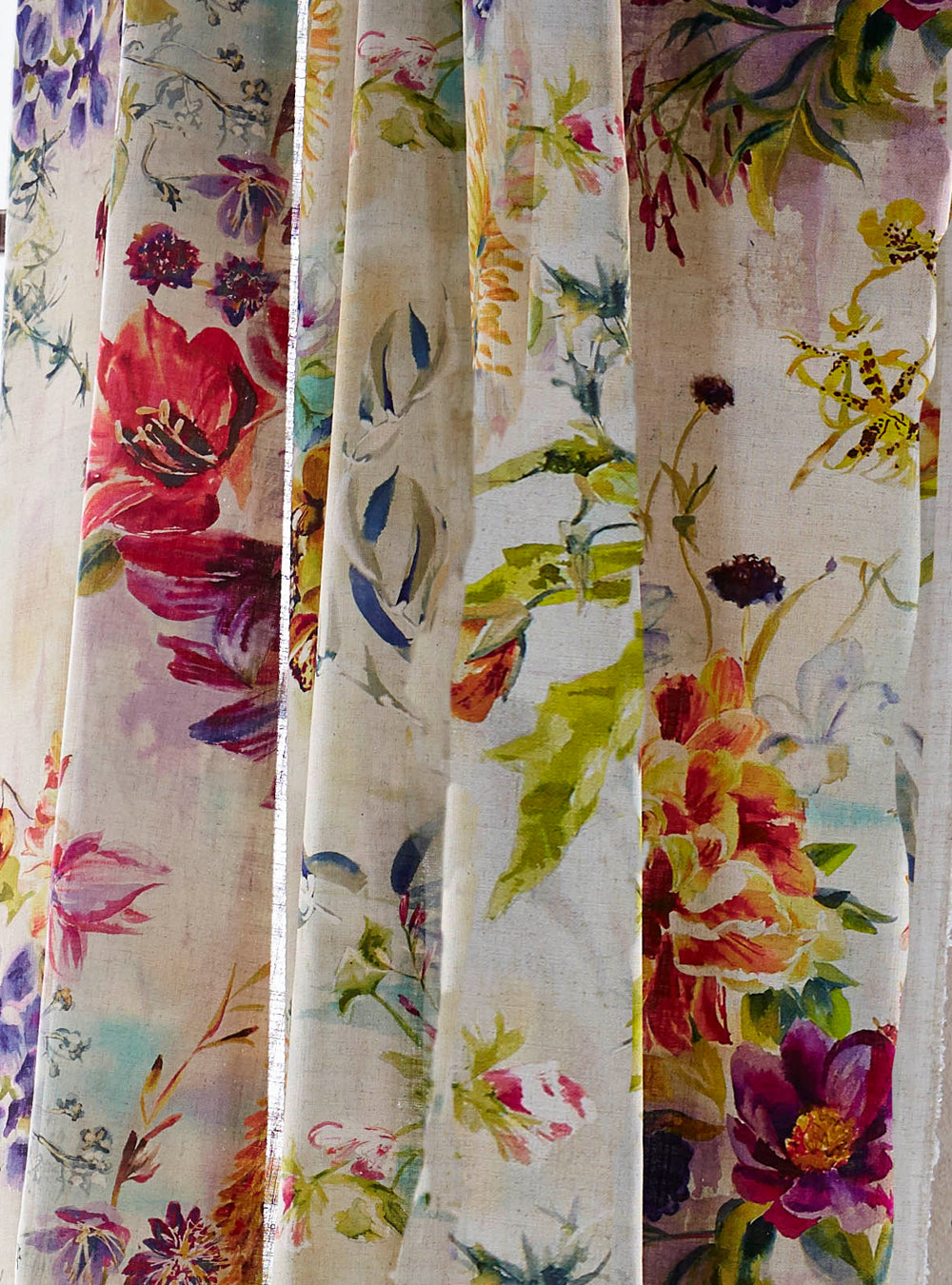 Draped fabric in a painterly floral print in a variety of colors on a mottled cream field.