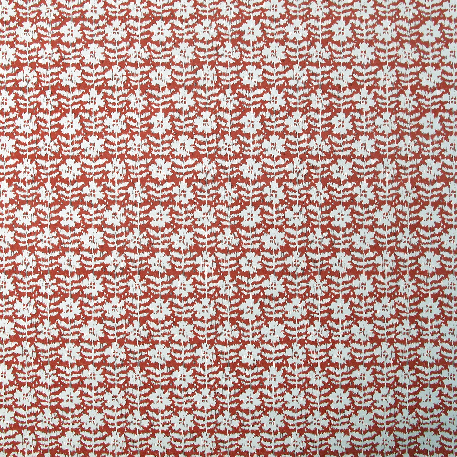 Detail of wallpaper in a floral grid print in white on a red field.