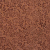 Detail of fabric in a paisley print in brown on a burnt orange field.