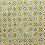 Detail of fabric in a floral lattice print in pink, yellow, teal and white.