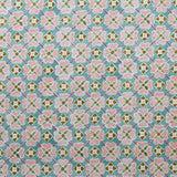 Detail of fabric in a floral lattice print in pink, teal, brown and white.