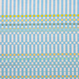 Detail of fabric in a dense irregular check print in light blue with yellow and green accents on a white field.