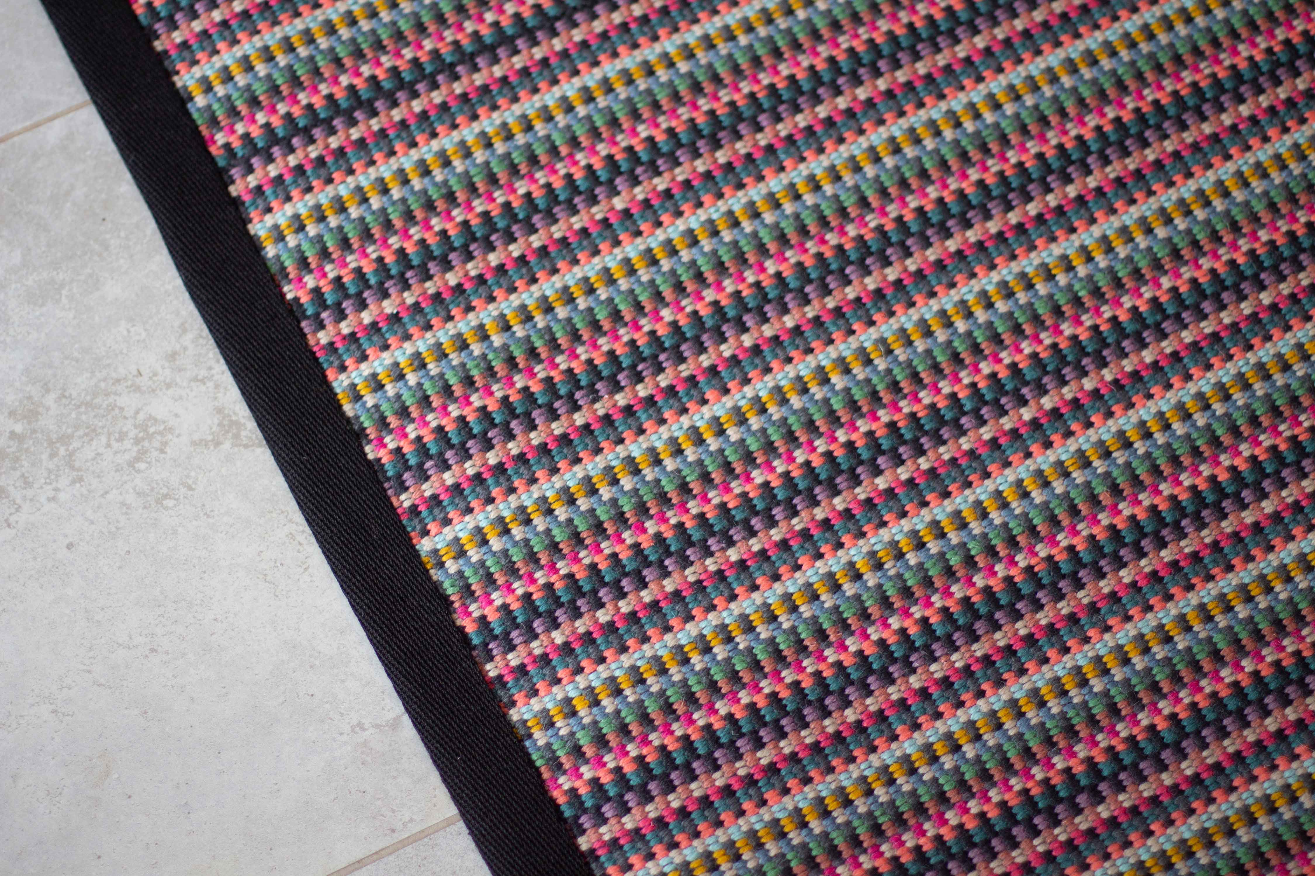 Striped flatweave runner in pink green purple blue with black border 