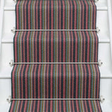 Striped flatweave runner in pink green purple blue with black border on white staircase