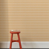 A green red stool with books  a wallpapered wall in a gridded check pattern in tan, cream ochre yellow. 