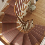 Striped flatweave runner in raspberry and red on wood staircase