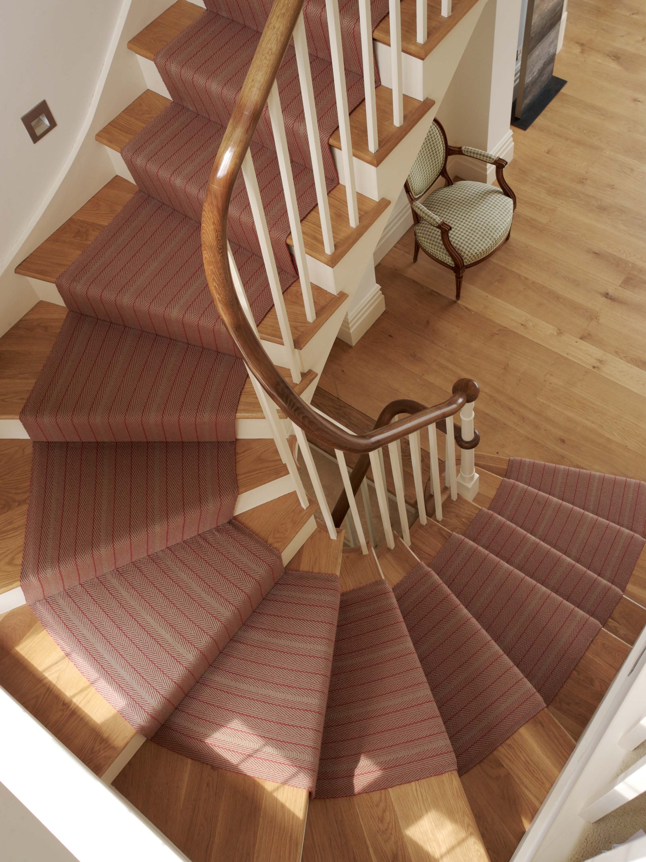 Striped flatweave runner in raspberry and red on wood staircase