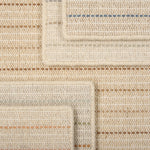 A stack of broadloom carpets in a dashed stripe pattern in a range of colors.