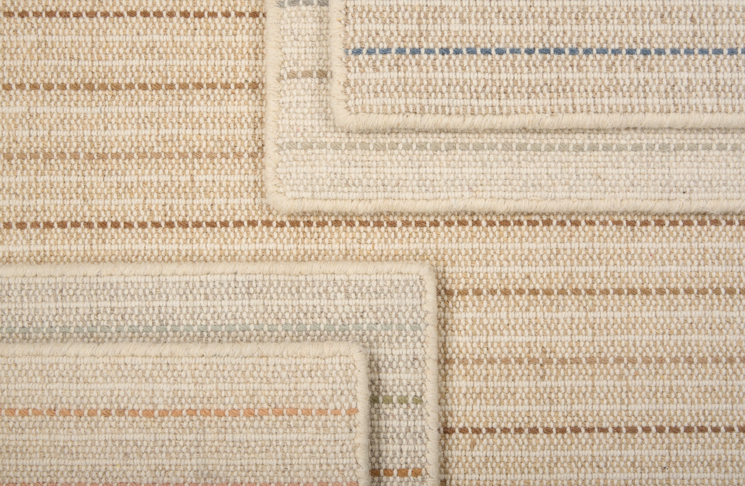 A stack of broadloom carpets in a dashed stripe pattern in a range of colors.