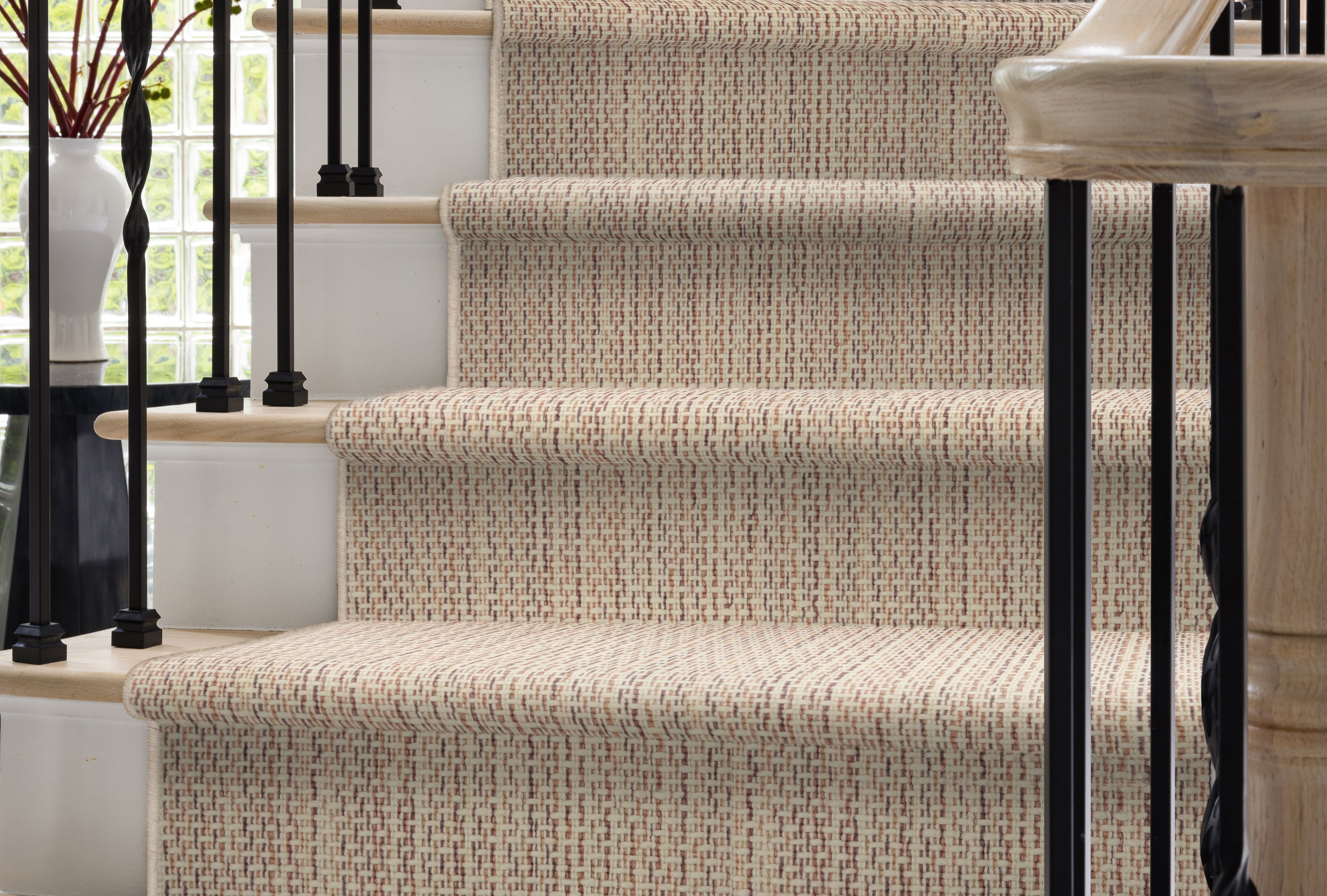 Staircase with textured beige carpeting in a home setting