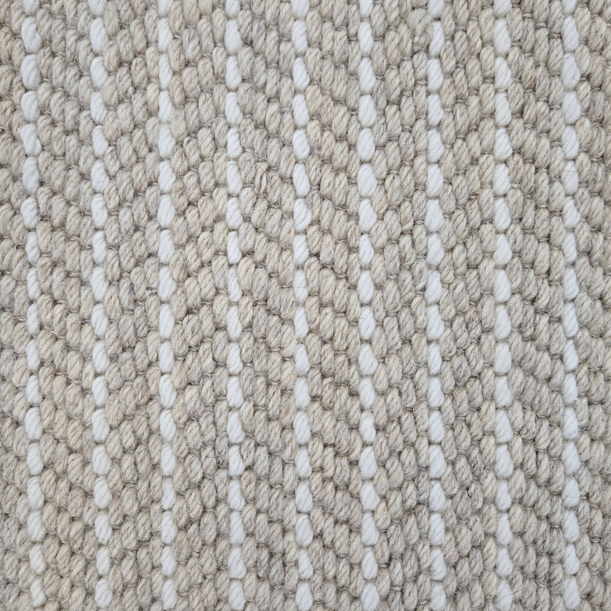 Close-up of a broadloom carpet with vertical stripes in beige and white.