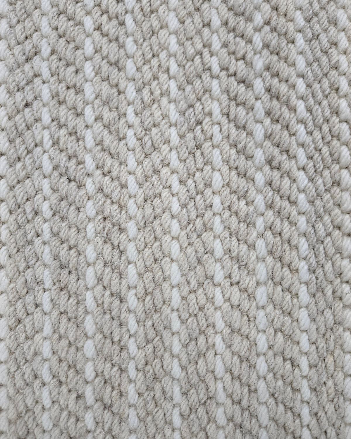Close-up of a broadloom carpet with vertical stripes in beige and white