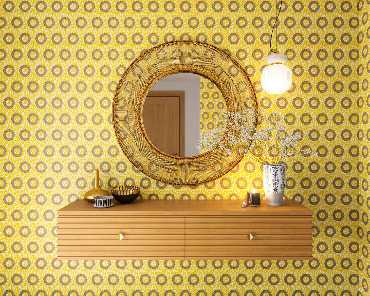 A floating shelf and statement mirror hang on a wall papered in an intricate circular print in yellow, purple and gray.